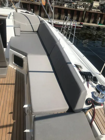  Yacht Photos Pics Luxury Jeanneau 54 yacht deck with cushioned seating, 2020 model, docked at marina.