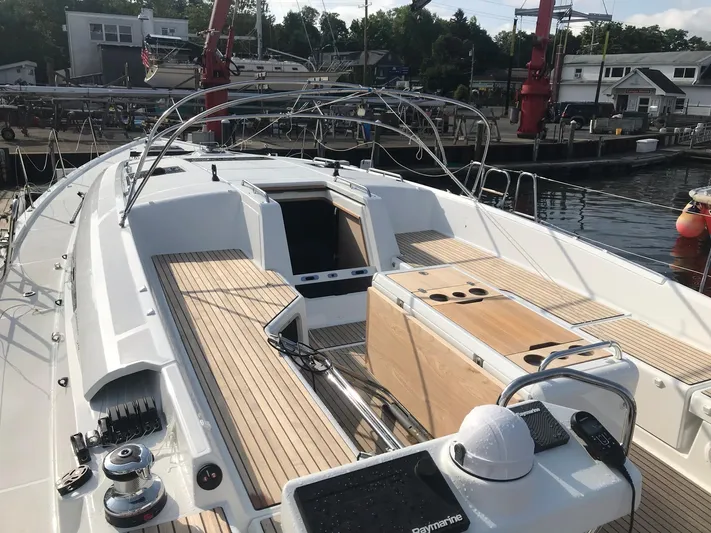  Yacht Photos Pics Jeanneau 54 sailboat deck, 2020 model, docked at marina with wooden seating and equipment.
