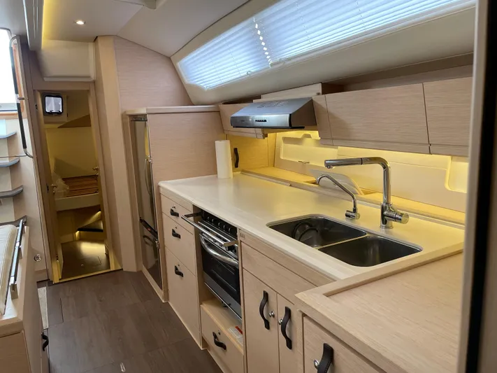  Yacht Photos Pics Modern kitchen interior of 2020 Jeanneau 54 yacht with sleek cabinetry and stainless steel appliances.