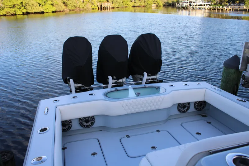  Yacht Photos Pics 2019 Conch 33 boat with covered engines, docked on a calm lake.