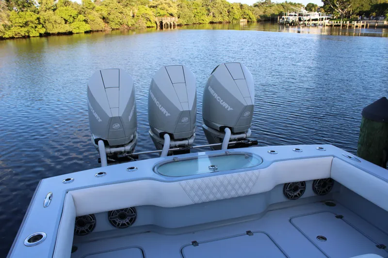  Yacht Photos Pics 2019 Conch 33 boat with triple Mercury engines on a calm lake.