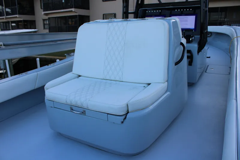  Yacht Photos Pics 2019 Conch 33 boat interior with cushioned seating and control panel.