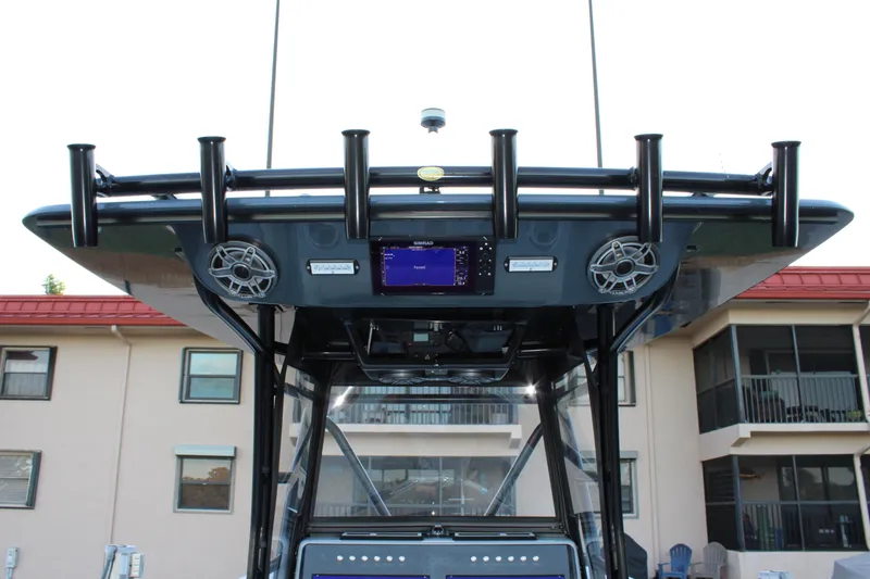  Yacht Photos Pics 2019 Conch 33 boat console with speakers and rod holders, docked near buildings.