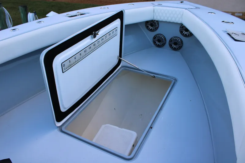  Yacht Photos Pics Open storage compartment on 2019 Conch 33 boat with ruler and speakers visible.