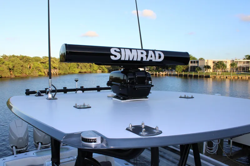  Yacht Photos Pics 2019 Conch 33 boat with Simrad radar on calm water, surrounded by lush greenery.