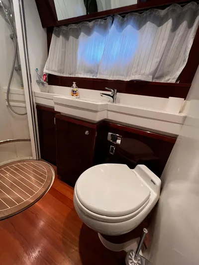  Yacht Photos Pics Bathroom interior of a 2008 Princess 50 yacht with shower and wooden flooring.