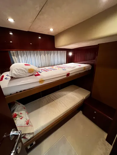  Yacht Photos Pics Bunk beds in a 2008 Princess 50 yacht cabin with cozy lighting and wooden finishes.