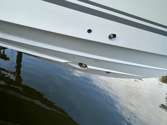  Yacht Photos Pics Close-up of 2019 HCB Siesta boat hull reflecting on water.