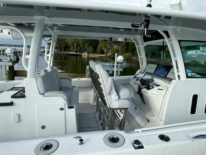  Yacht Photos Pics 2019 HCB Siesta boat interior with seating and control panel, docked by a serene waterfront.