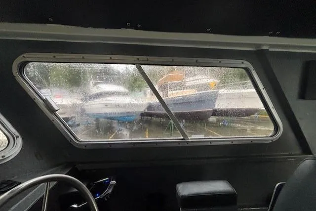 Uno Yacht Photos Pics Interior view from a 2012 Jaxoncraft Custom Hardtop boat, looking out at rainy docked boats.