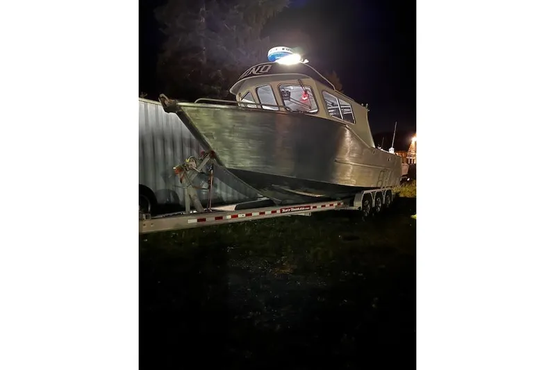 Uno Yacht Photos Pics Custom 2012 Jaxoncraft Hardtop boat on trailer at night, illuminated by lights.