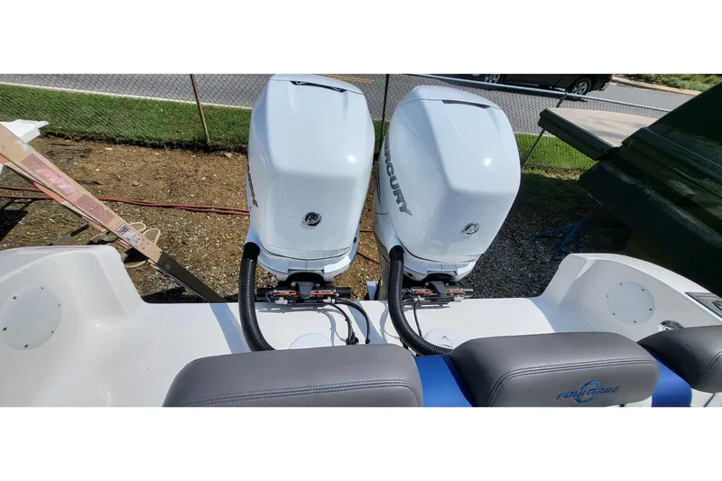  Yacht Photos Pics Twin Mercury outboard engines on a 2022 Fountain 34 SC boat, parked outdoors.