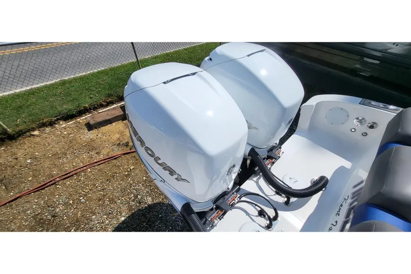  Yacht Photos Pics Twin Mercury outboard engines on a 2022 Fountain 34 SC boat, parked on gravel.