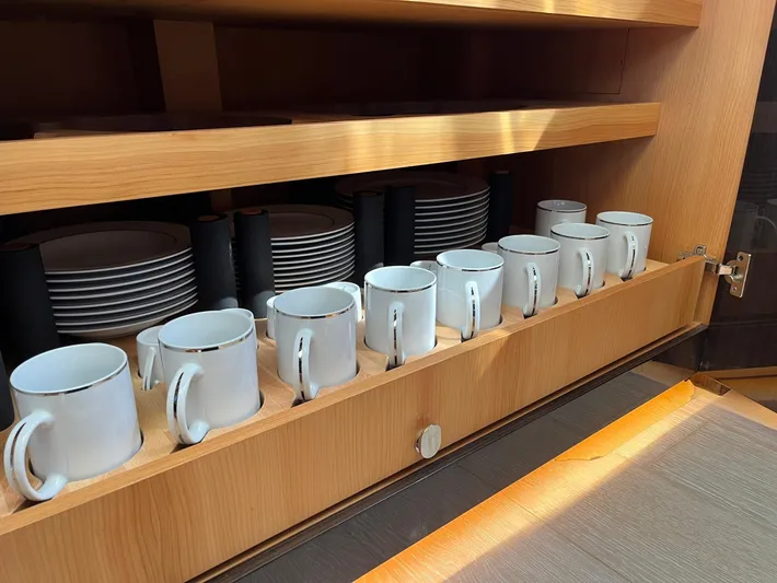  Yacht Photos Pics Wooden cabinet with neatly arranged white mugs and plates on an Azimut 77S yacht.