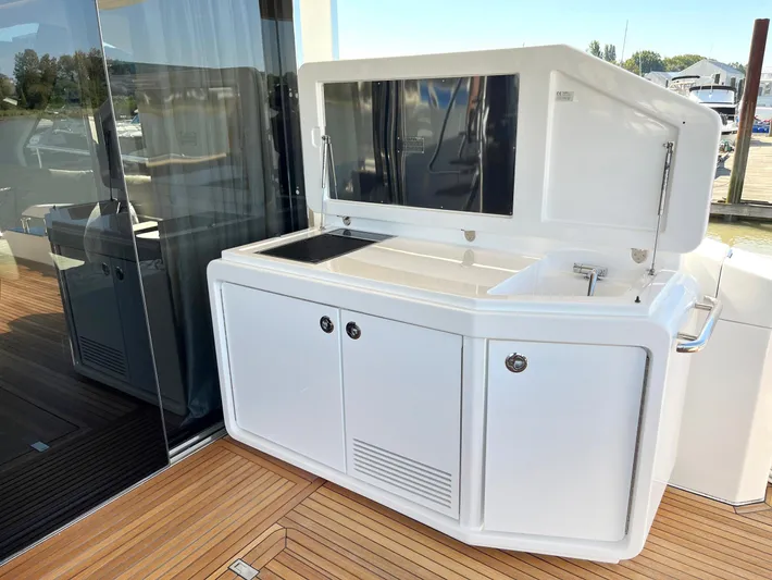  Yacht Photos Pics Outdoor kitchen on 2016 Azimut 77S yacht with sleek cabinetry and wooden deck.
