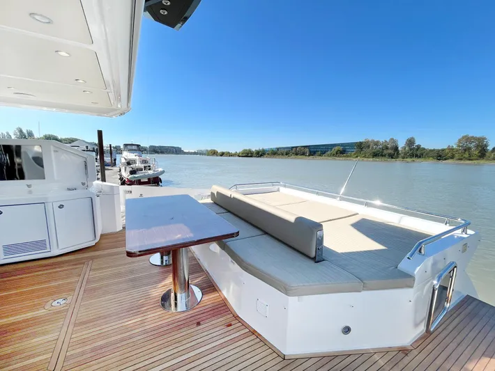  Yacht Photos Pics Luxurious 2016 Azimut 77S yacht deck with seating and table, overlooking serene waters.