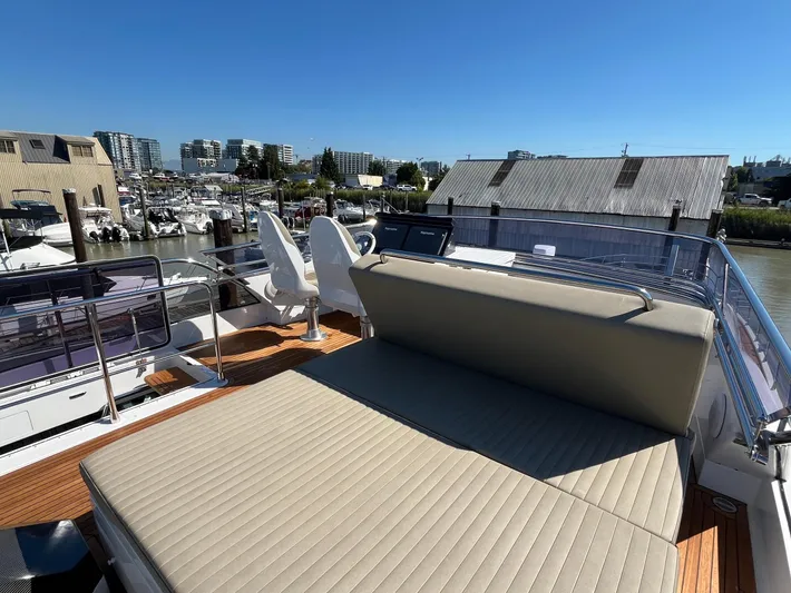  Yacht Photos Pics Luxurious 2016 Azimut 77S yacht deck with seating, docked in a marina under clear blue skies.