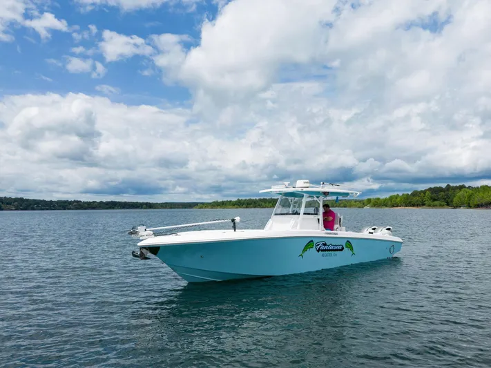 Fantasea Yacht Photos Pics 2019 Fountain 34CC boat on a lake under a partly cloudy sky.