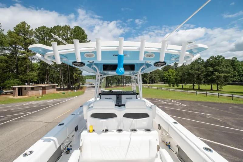 Fantasea Yacht Photos Pics 2019 Fountain 34CC boat with T-top and rod holders in a parking lot.