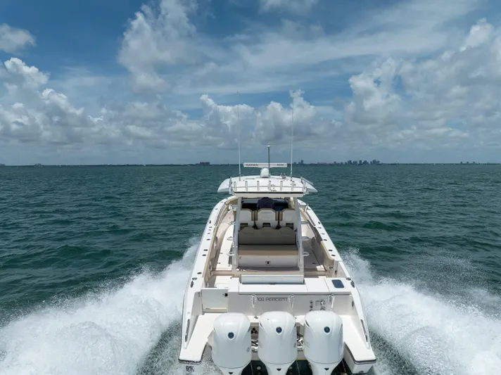 100 Percent Yacht Photos Pics 2018 Pursuit S 368 Sport boat cruising on open water under a cloudy sky.