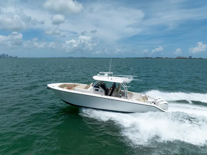 100 Percent Yacht Photos Pics 2018 Pursuit S 368 Sport boat cruising on open water under a clear sky.