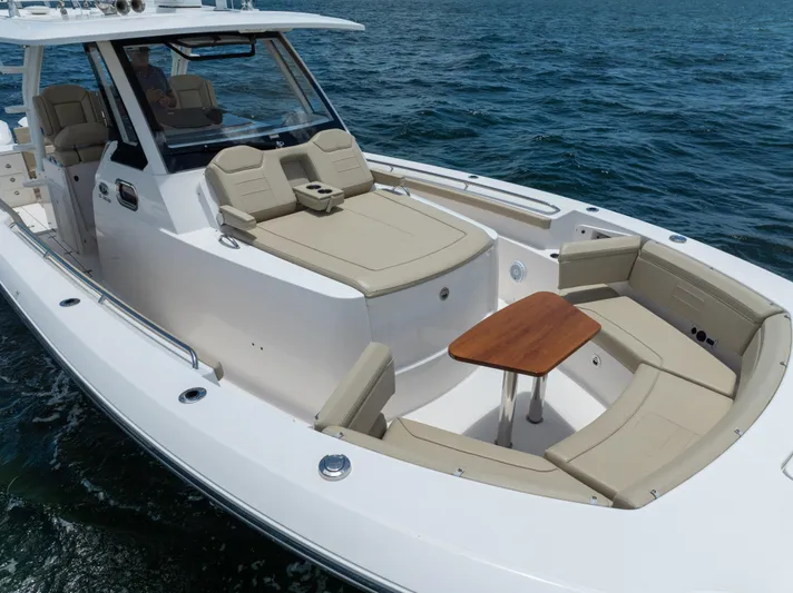 100 Percent Yacht Photos Pics 2018 Pursuit S 368 Sport boat with spacious seating and table on open water.