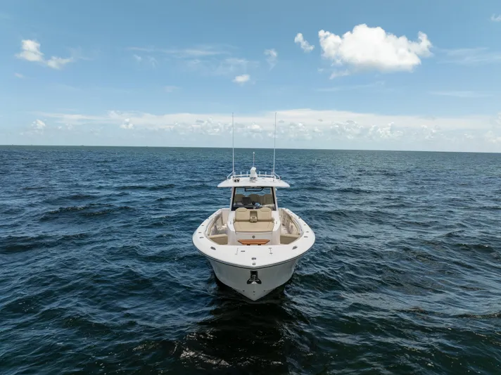 100 Percent Yacht Photos Pics 2018 Pursuit S 368 Sport boat on open ocean under clear blue sky.