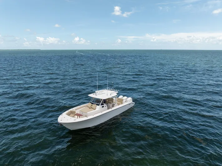 100 Percent Yacht Photos Pics 2018 Pursuit S 368 Sport boat on open ocean under clear blue sky.