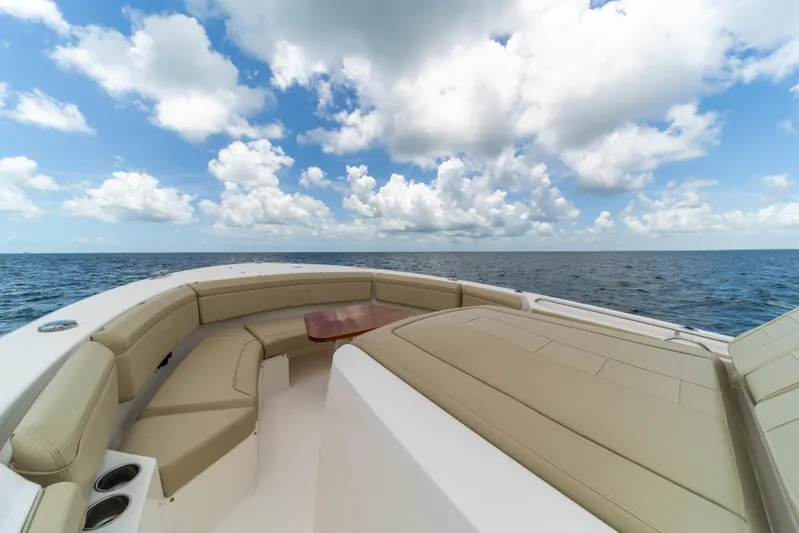 100 Percent Yacht Photos Pics 2018 Pursuit S 368 Sport boat with spacious seating, ocean view, and cloudy sky.