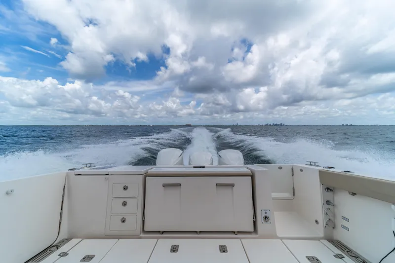 100 Percent Yacht Photos Pics 2018 Pursuit S 368 Sport boat cruising on open water under a cloudy sky.