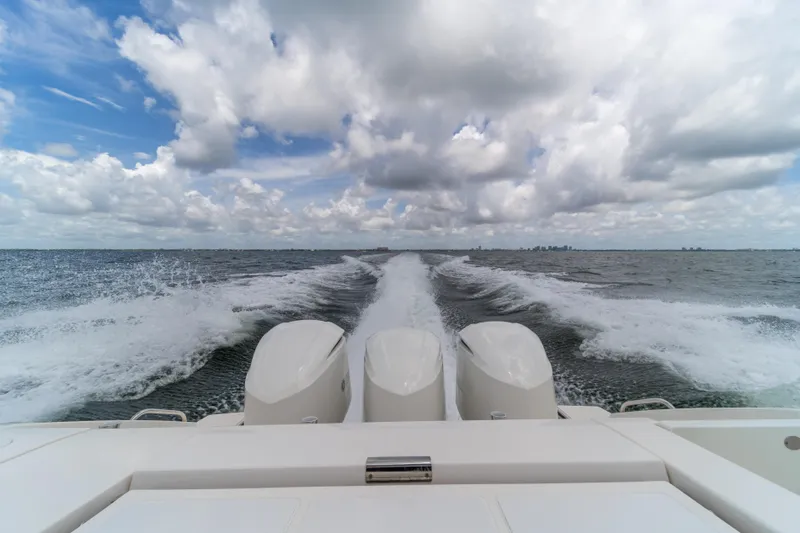 100 Percent Yacht Photos Pics 2018 Pursuit S 368 Sport boat cruising on open water under cloudy sky.