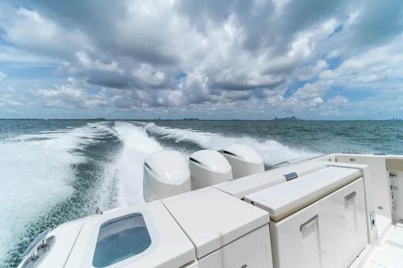 100 Percent Yacht Photos Pics 2018 Pursuit S 368 Sport boat cruising on open water under cloudy sky.