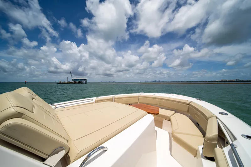 100 Percent Yacht Photos Pics 2018 Pursuit S 368 Sport boat with spacious deck, under a partly cloudy sky.