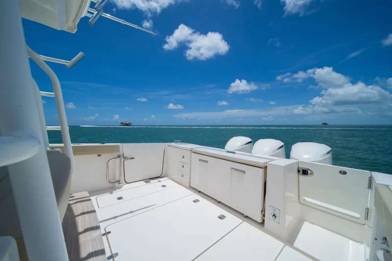 100 Percent Yacht Photos Pics 2018 Pursuit S 368 Sport boat deck with ocean view under blue sky.