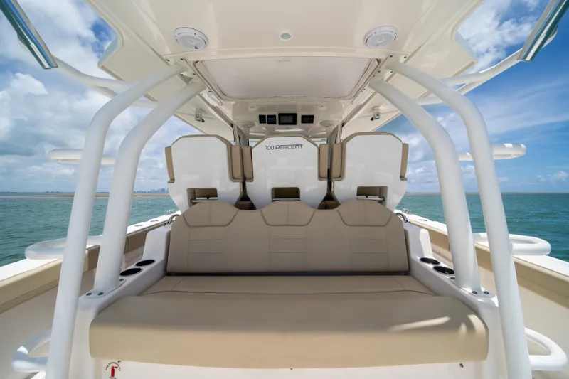 100 Percent Yacht Photos Pics 2018 Pursuit S 368 Sport boat interior with beige seating, ocean view.