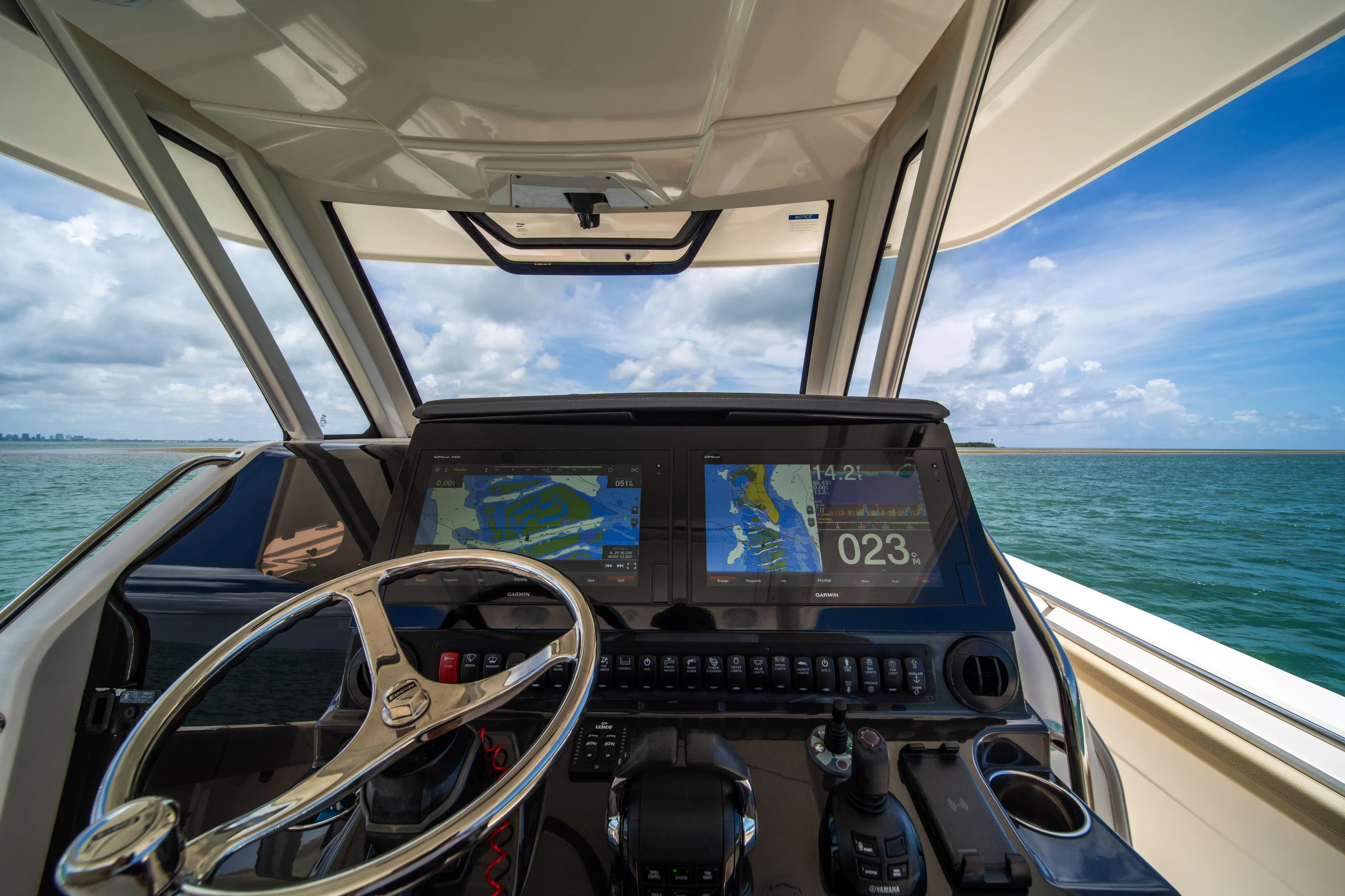 100 Percent Yacht Photos Pics Helm of 2018 Pursuit S 368 Sport boat with navigation screens, steering wheel, and ocean view.