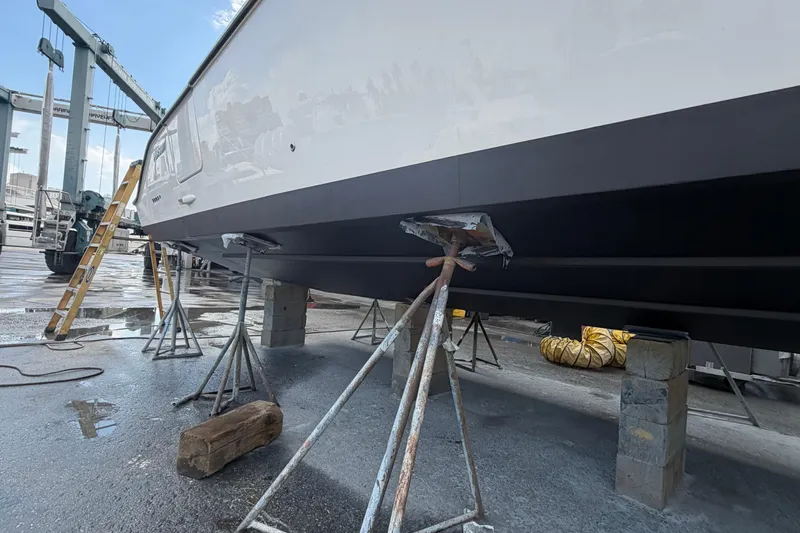 100 Percent Yacht Photos Pics 2018 Pursuit S 368 Sport boat on stands in a shipyard for maintenance.