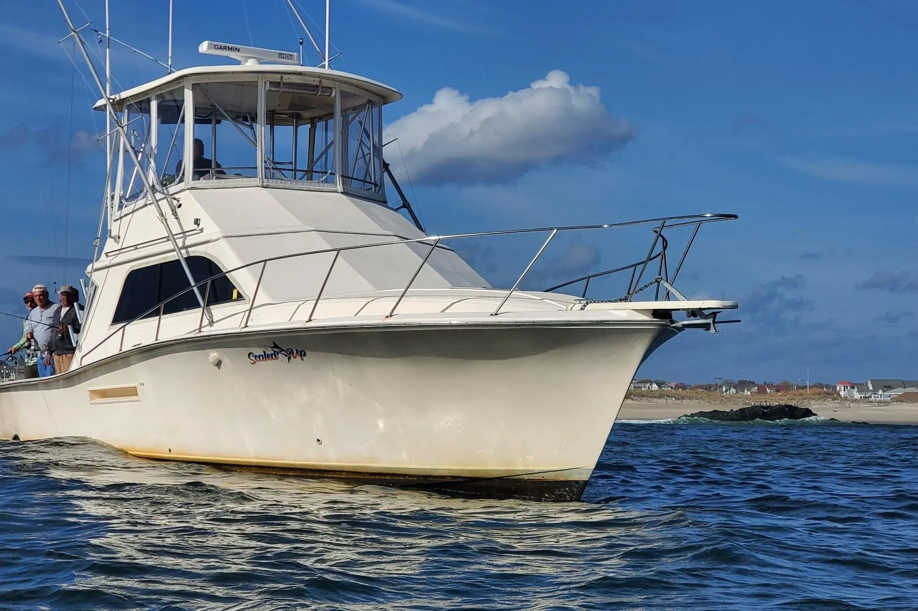 1991 Pacemaker 37 Sportfisherman boat on water, clear sky, people onboard.