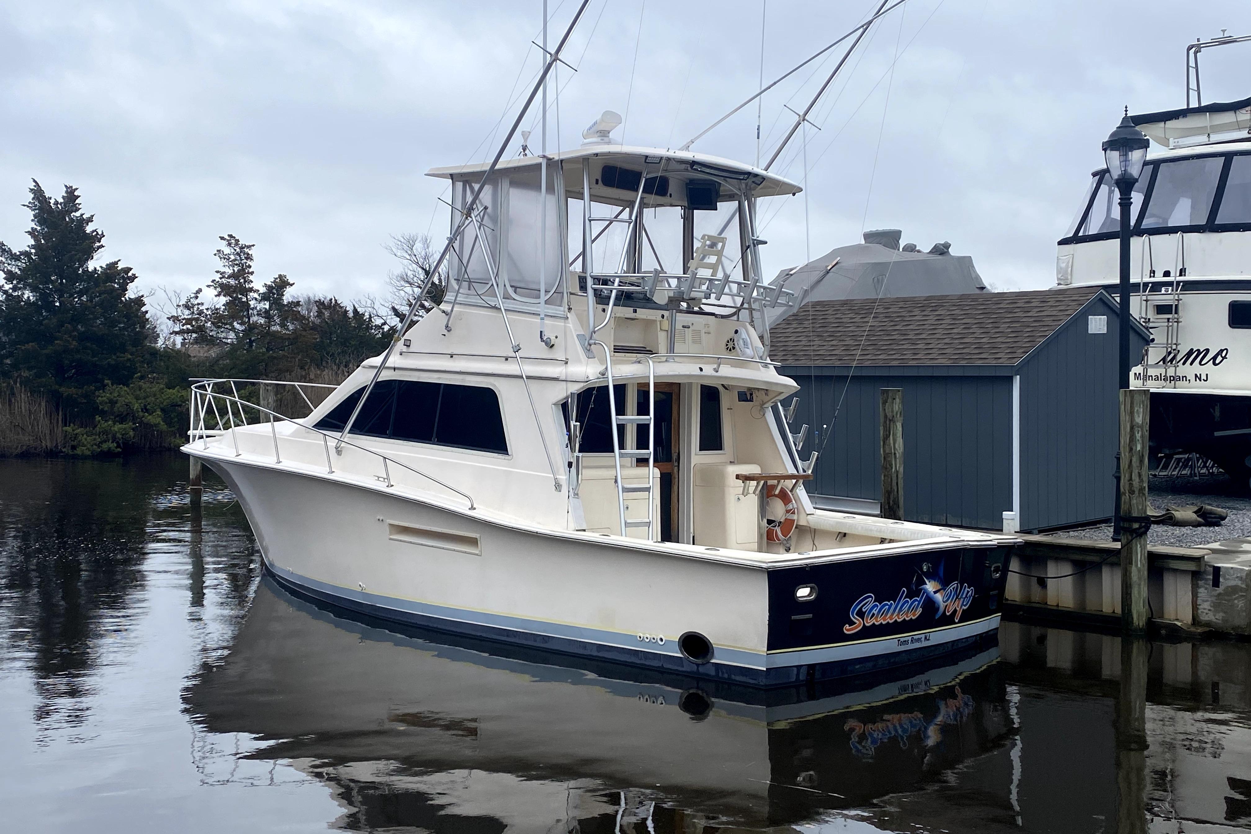 1991 Pacemaker 37 Sportfisherman boat docked in a marina, overcast sky.