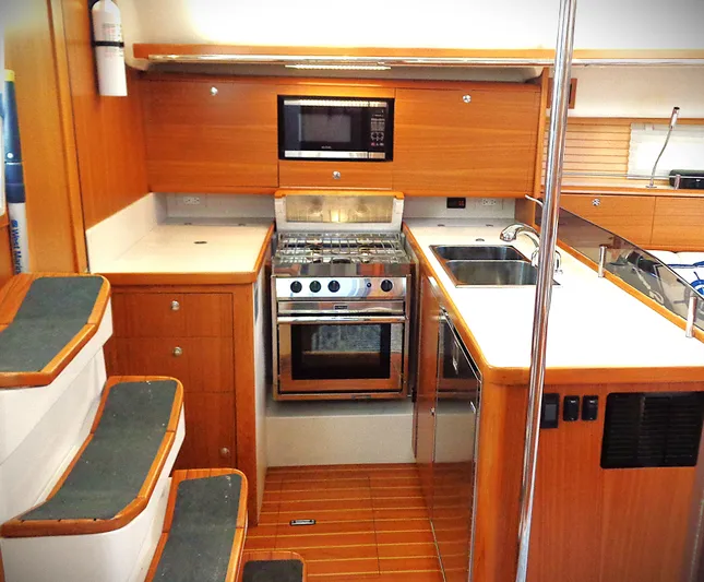 Meru Yacht Photos Pics Modern kitchen interior of 2019 Catalina 425 yacht with wood finish and stainless steel appliances.