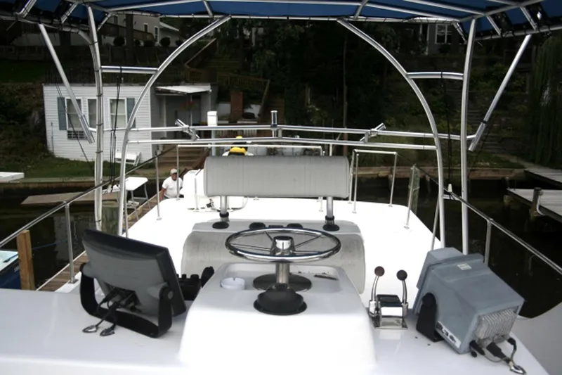 Delight Yacht Photos Pics 2002 Magna Marine 45 Flybridge boat helm with navigation equipment and canopy.