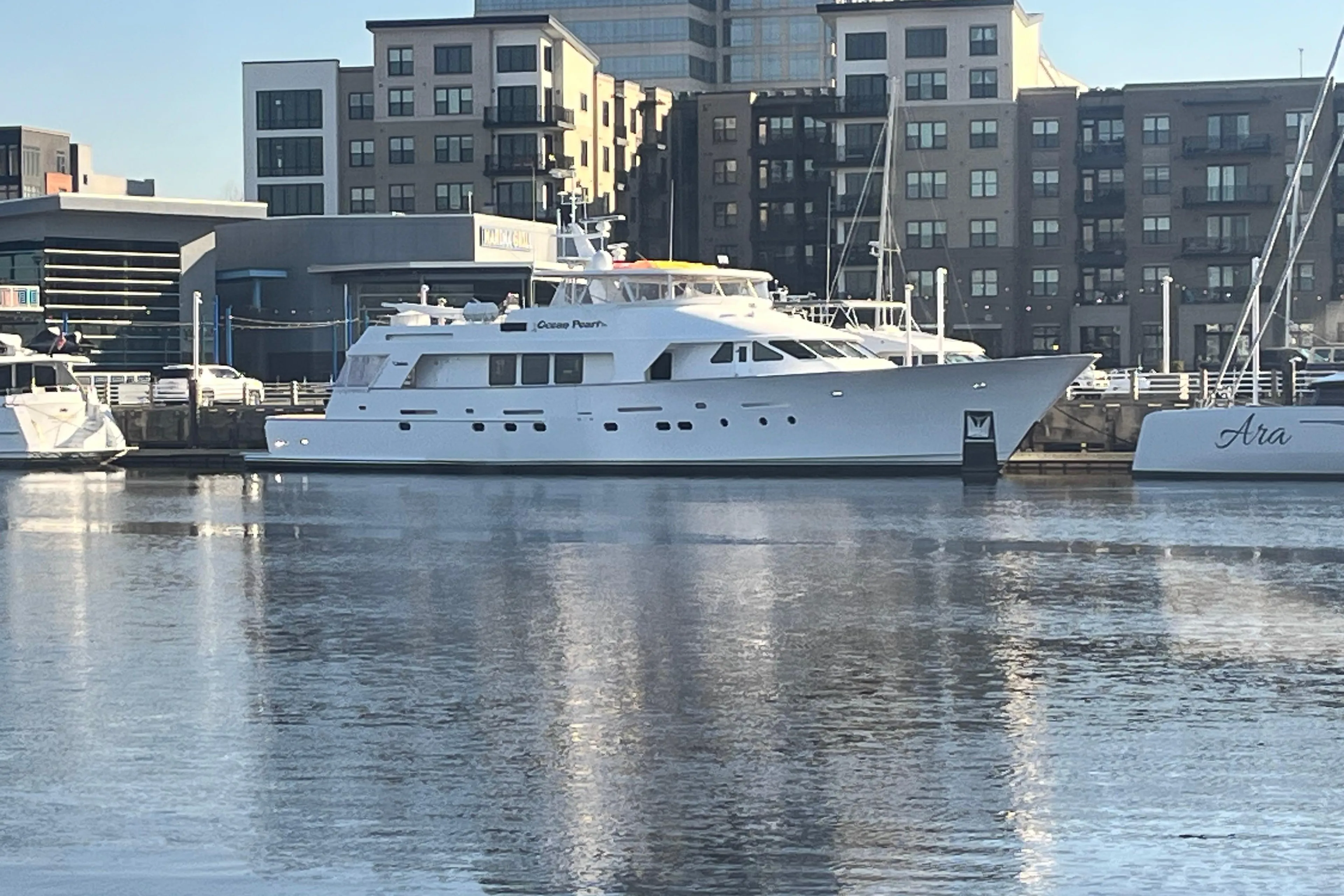 1988 Christensen Custom yacht docked in urban marina, reflecting on calm water.