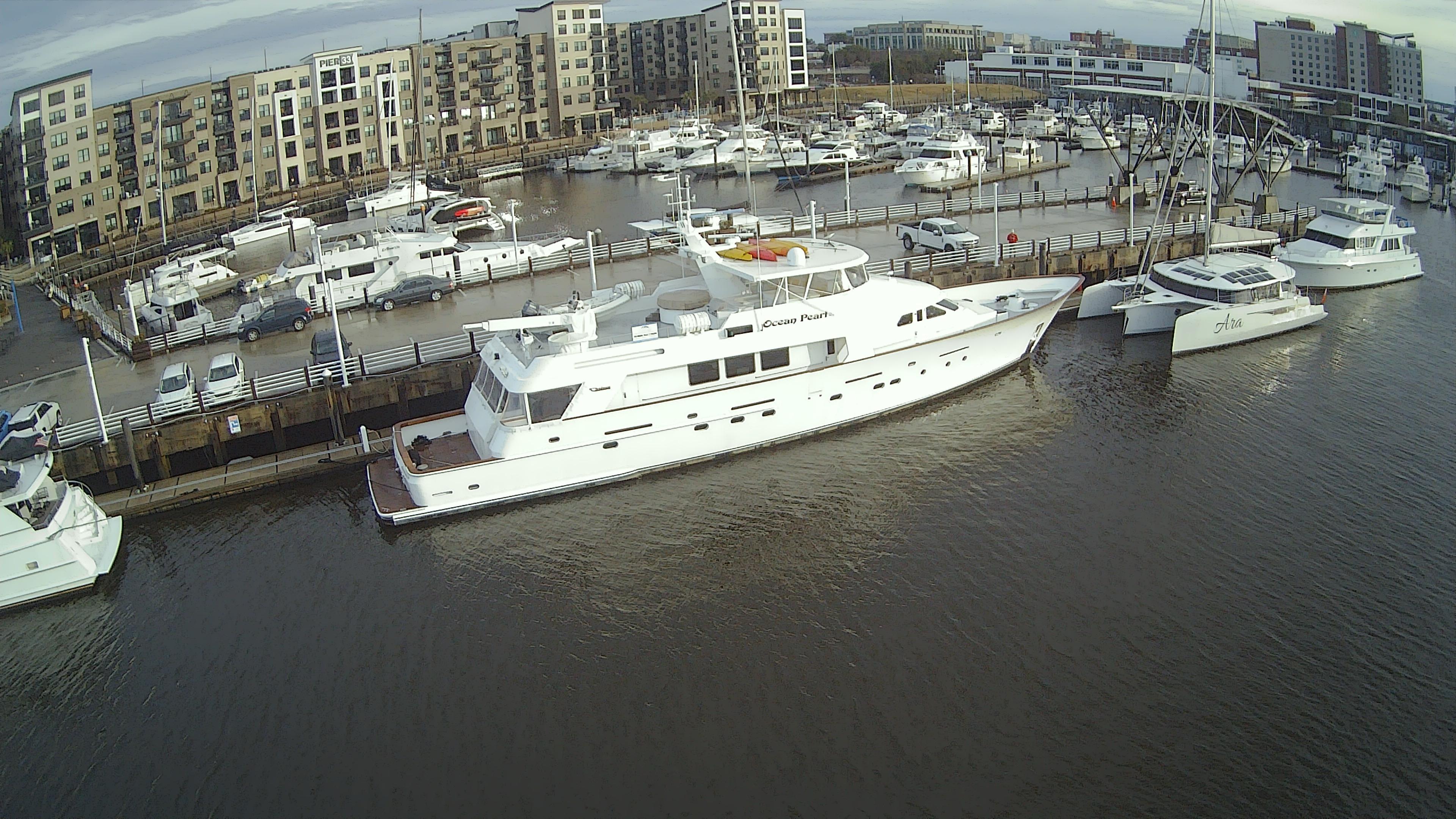 1988 Christensen Custom yacht docked in marina, surrounded by buildings.