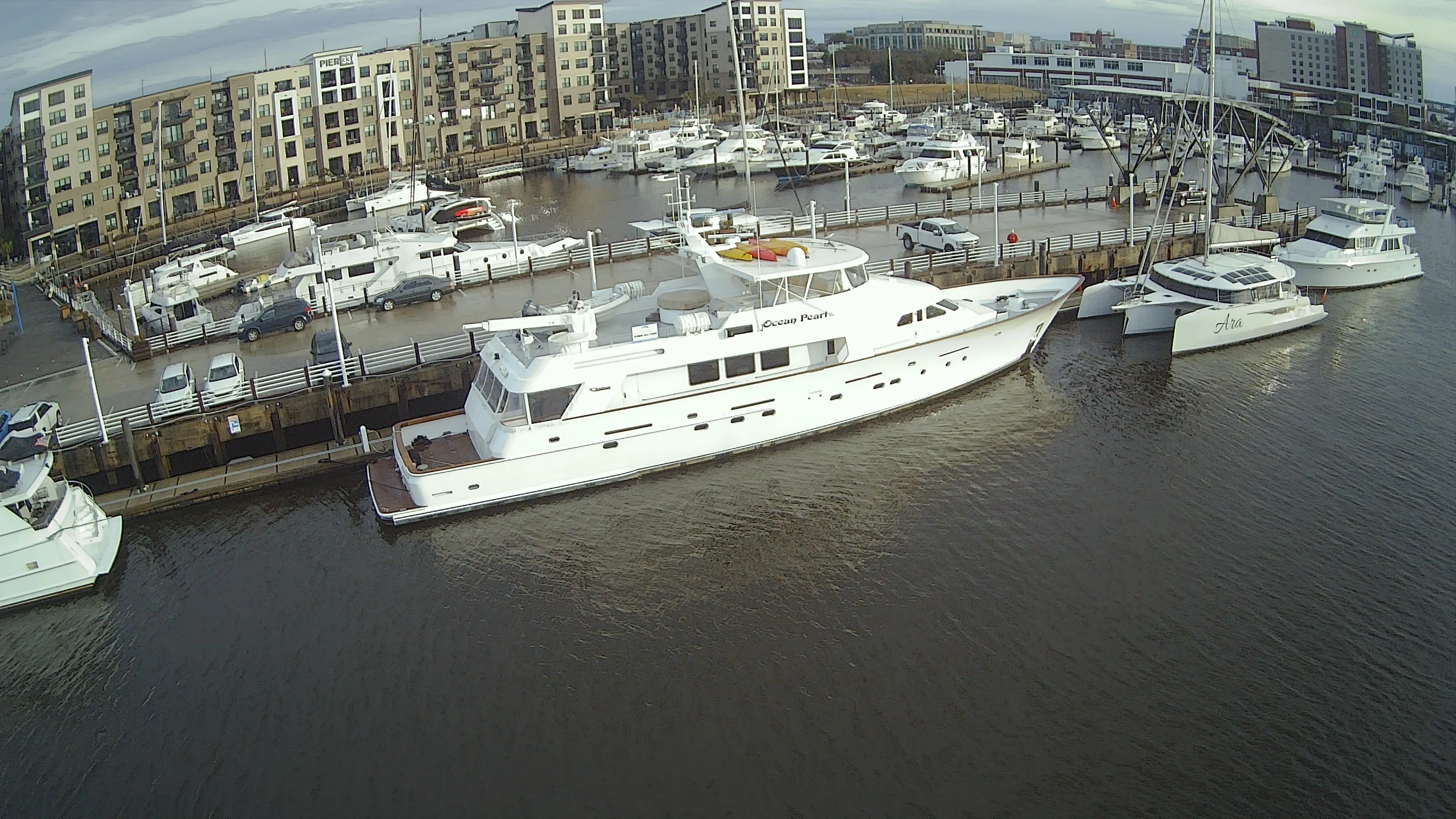 1988 Christensen Custom yacht docked in marina, surrounded by buildings.