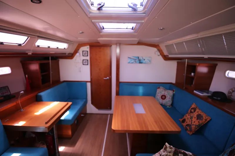  Yacht Photos Pics Interior of 2007 Hanse 430e yacht with blue seating and wooden tables.