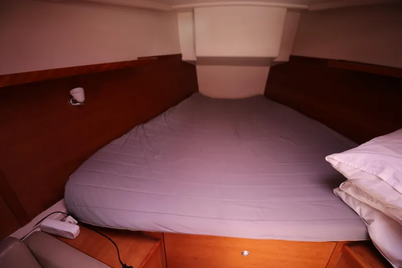  Yacht Photos Pics Cozy cabin bed in 2007 Hanse 430e sailboat, featuring wooden accents and soft lighting.