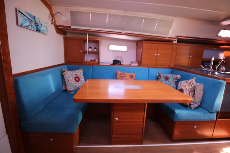  Yacht Photos Pics Interior of 2007 Hanse 430e yacht with blue seating and wooden table.