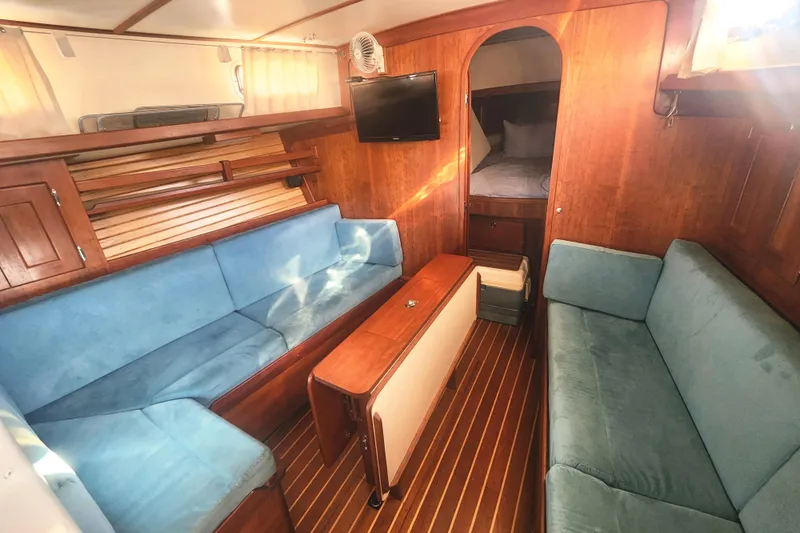 Fidelity Yacht Photos Pics Interior of 2010 Valiant 42 CE/SE yacht with blue seating and wooden finishes.