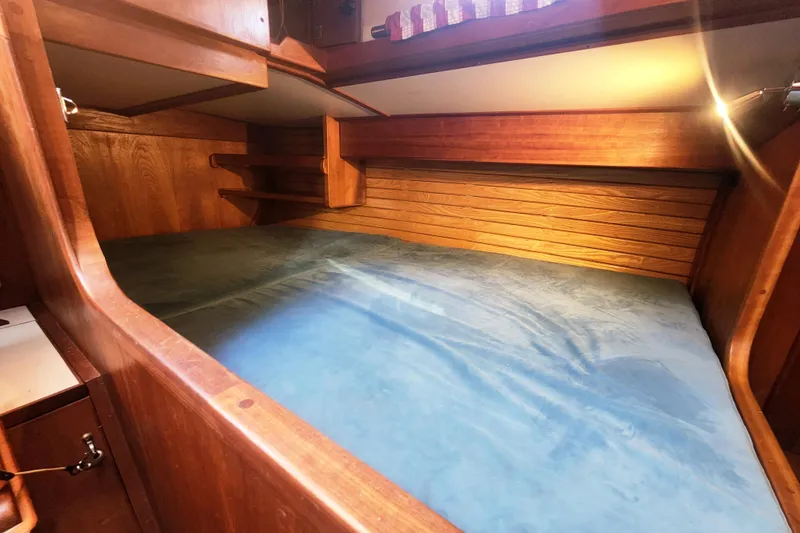 Fidelity Yacht Photos Pics Cozy wooden cabin interior of 2010 Valiant 42 CE/SE sailboat with blue bedding.
