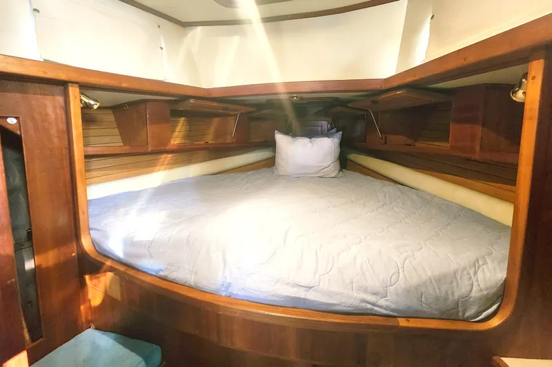 Fidelity Yacht Photos Pics Cozy cabin interior of 2010 Valiant 42 CE/SE sailboat with wooden finish and comfortable bedding.